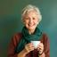 Portret van Nies Overdiek, een tevreden senior vrouw met een kop koffie